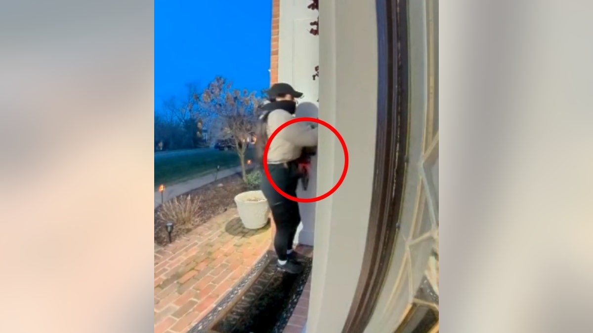 Woman holding roses rings a doorbell at a home in Fairfax County, Vriginia