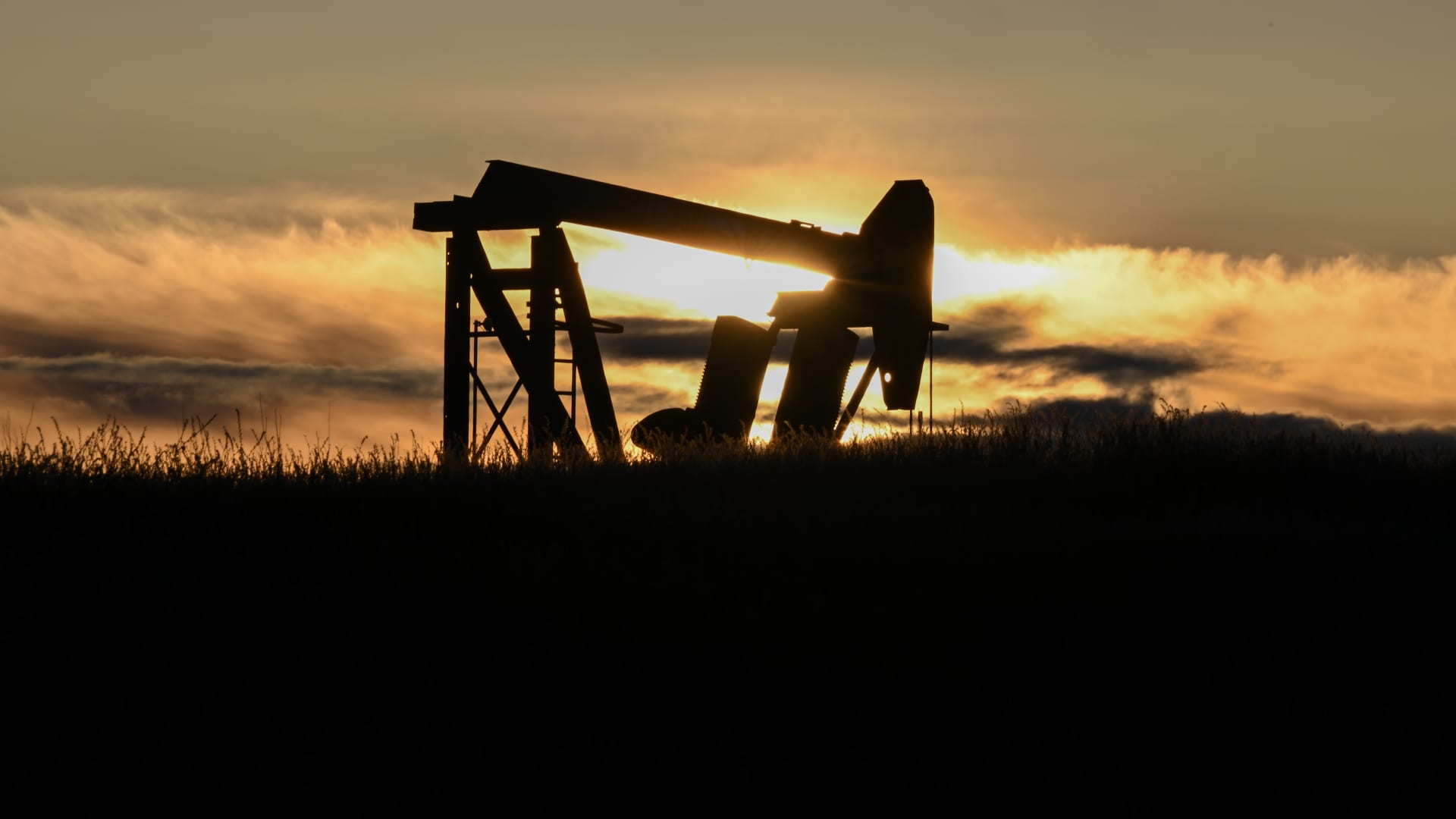 Image of an oil well in action during sunset in the Elk Hills Oil Field, California