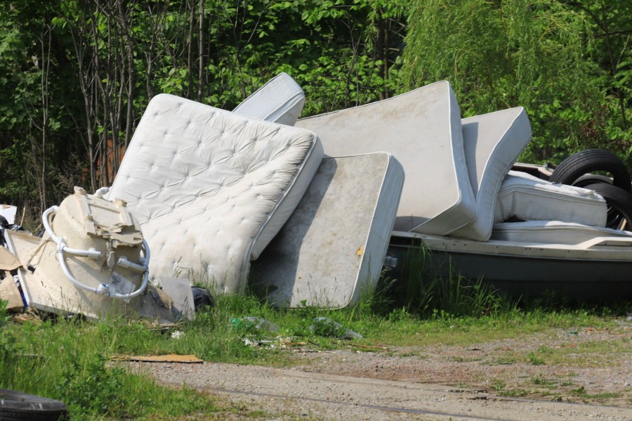 Several mattresses and box springs are shown dumped illegally in a field in this undated photo. (Getty Images)