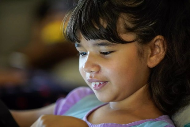 Alyssa Tracy, 10, engages with an activity on her tablet at home. In some cases, an autism diagnosis is delayed because girls may be seen merely as quieter or shy, rather than demonstrating clear symptoms. Research over the past decade has helped reveal that boys and girls may present symptoms in different ways. (Alejandro Tamayo/The San Diego Union-Tribune/TNS)